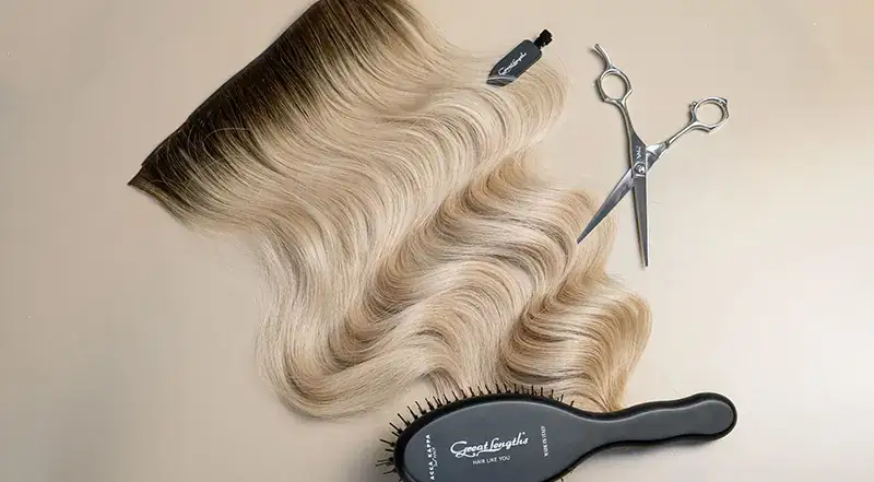 Great Lengths GL Weft Linea Wien – blonde Haartressen für Weft-Extensions, liegend mit Haarbürste und Schere auf hellem Hintergrund
